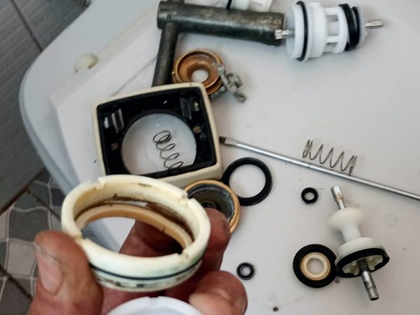Peças de válvula Hydra desmontadas, com o reparo desgastado ao lado da peça nova